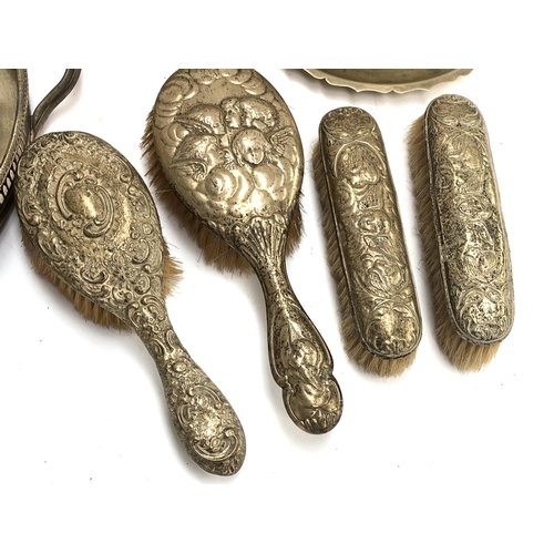 155 - Four silver topped brushes, three with repousse cherub design, together with a quantity of silver pl... 