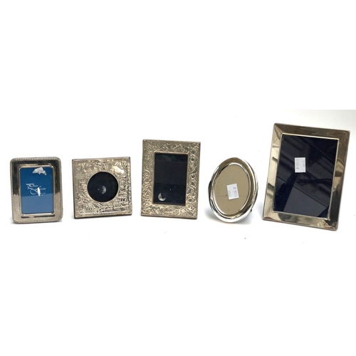 156 - Two silver photo frames, stamped 958, together with further photo frames