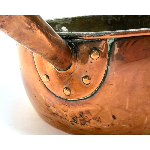 1244 - A large copper saucepan with riveted handle; together with a brass pan with iron loop handle, each a... 