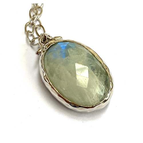 14 - A sterling silver double sided pendant set with faceted labradorite, 31cts, and moonstone, 31.5cts, ... 