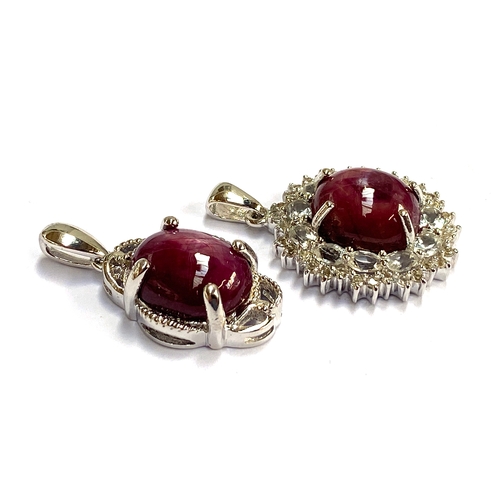 26 - Two sterling silver pendants: one star ruby pendant, 13.9cts; the other a star ruby and white topaz ... 