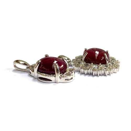 26 - Two sterling silver pendants: one star ruby pendant, 13.9cts; the other a star ruby and white topaz ... 