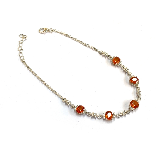 31 - A sterling silver bracelet set with mandarin garnets, 4.9cts, and white zircons, 22cmL unclasped