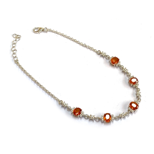 31 - A sterling silver bracelet set with mandarin garnets, 4.9cts, and white zircons, 22cmL unclasped