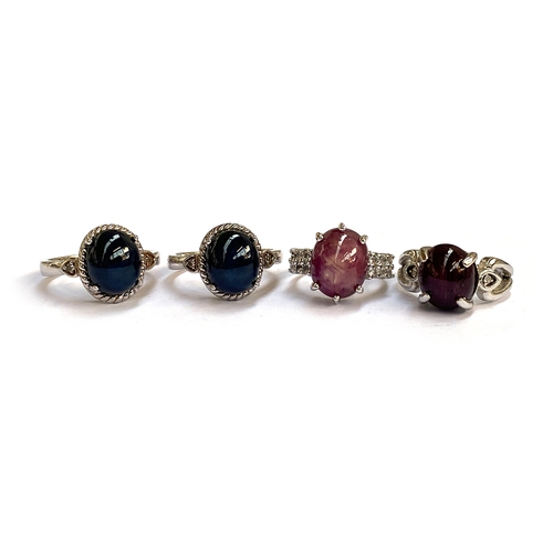 35 - A group of four sterling silver set star ruby and star sapphire rings, the Madagascan sapphires 7.5c... 