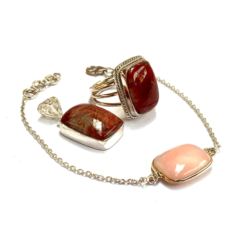 38 - A sterling silver ring set with fossilised red coral, 15cts, together with a matching pendant; toget... 