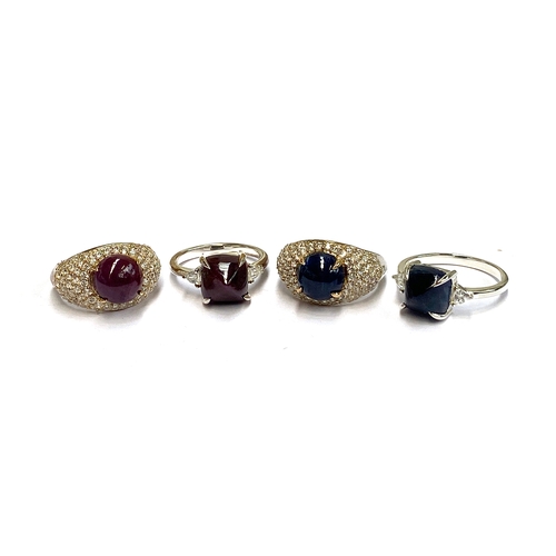 4 - A lot of four sterling silver rings: two set with ruby and sapphire cabochons, with 18ct gold claws,... 