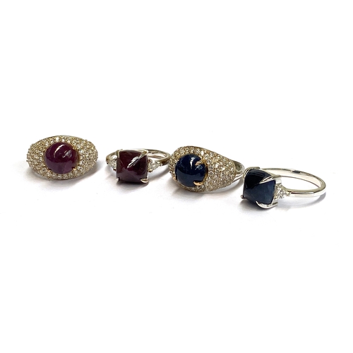 4 - A lot of four sterling silver rings: two set with ruby and sapphire cabochons, with 18ct gold claws,... 