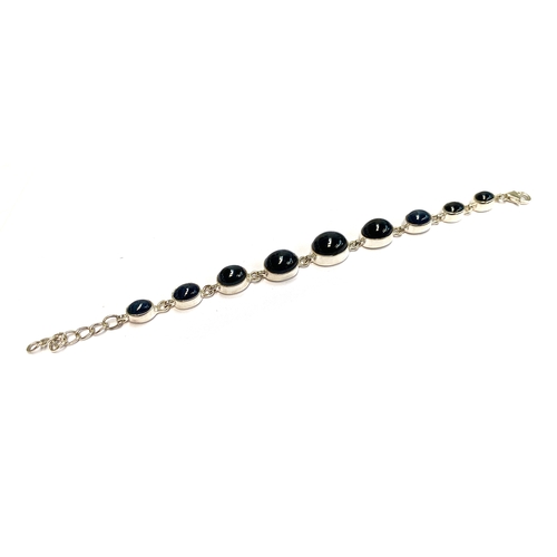 7 - A sterling silver bracelet set with nine blue star sapphire cabochons, the Madagascan sapphires tota... 