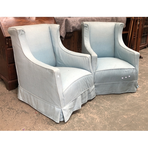 1372 - A pair of blue upholstered armchairs (one caster missing), 74cmW