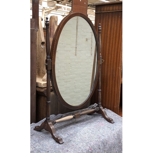 1350 - An oval dressing mirror on turned supports, 70cmH