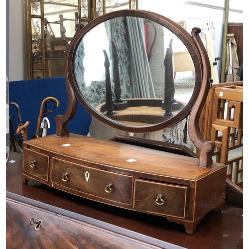 1354 - A George III mahogany bowfront toilet mirror with three drawers, oval plate, 54cmW