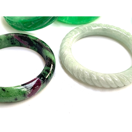 132 - Six carved jade bangles; together with a ruby zoisite bangle