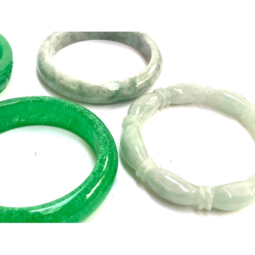 132 - Six carved jade bangles; together with a ruby zoisite bangle