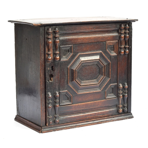 354 - A Charles II oak spice cupboard, the geometric carved door with applied half turned decoration, open... 