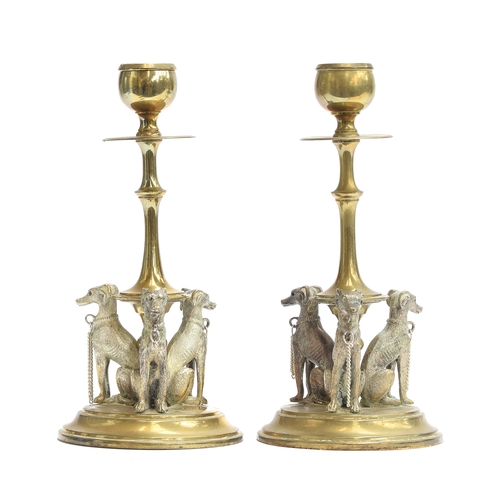 149 - A pair of 19th century French brass candlesticks, the flared stem on a circular base with three seat... 