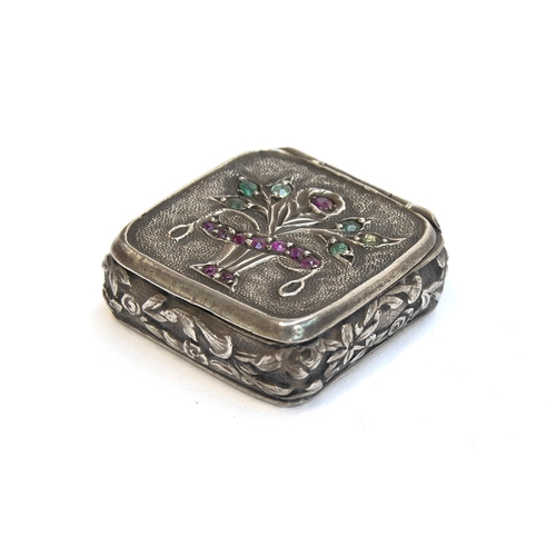 88 - A late 19th century small silver pill box, the lid decorated with a giardinetti style stand of flowe... 