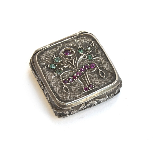 88 - A late 19th century small silver pill box, the lid decorated with a giardinetti style stand of flowe... 