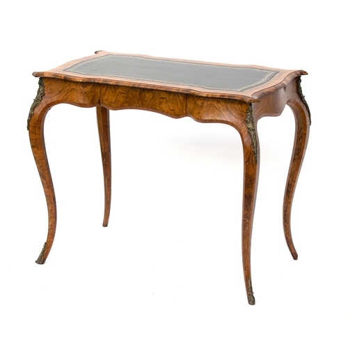 429 - A 19th century French walnut and cross banded writing table, the shaped top with tooled leather skiv... 