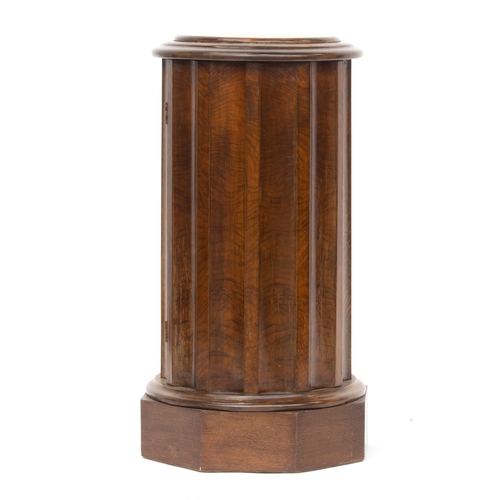 453 - A mahogany pedestal, in the form of a reeded column, the circular moulded top over a cupboard, on an... 