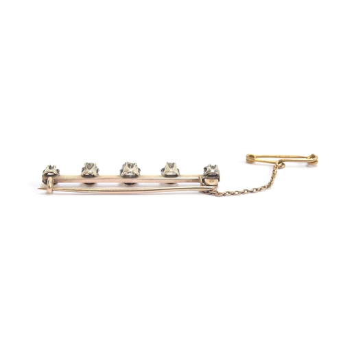 22 - A Victorian gold and silver bar brooch set with five old cut diamonds, the largest central diamond a... 