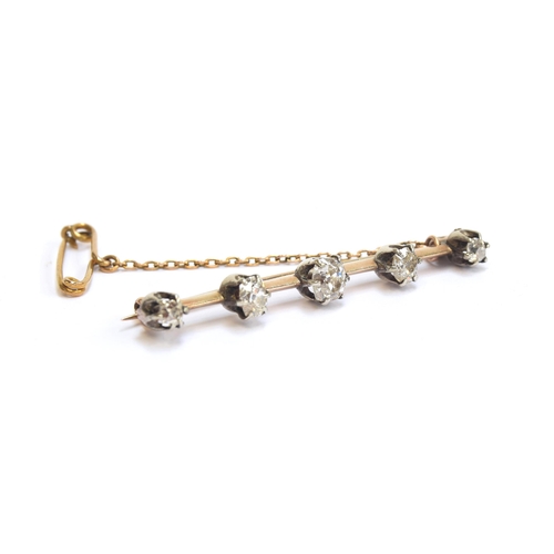 22 - A Victorian gold and silver bar brooch set with five old cut diamonds, the largest central diamond a... 