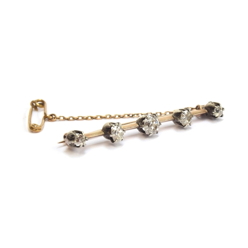 22 - A Victorian gold and silver bar brooch set with five old cut diamonds, the largest central diamond a... 