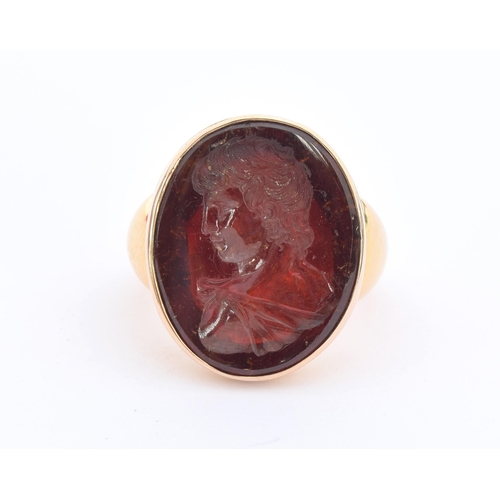 11 - A large and heavy Georgian gold mounted garnet intaglio portrait ring, the gold in two colours, the ... 