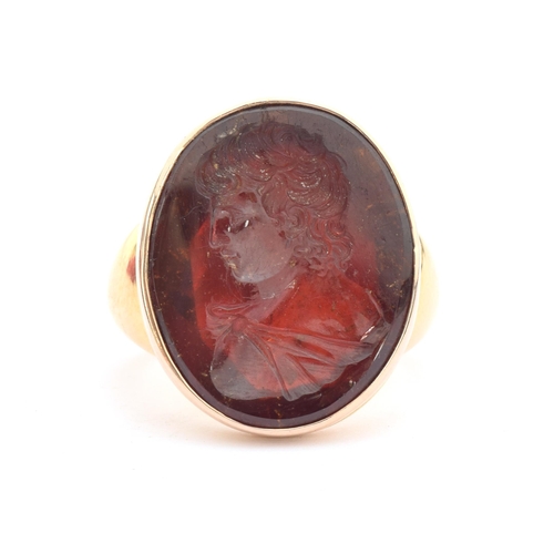 11 - A large and heavy Georgian gold mounted garnet intaglio portrait ring, the gold in two colours, the ... 