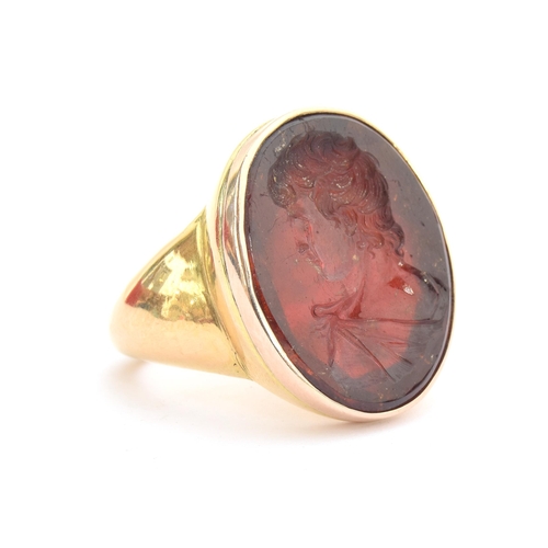 11 - A large and heavy Georgian gold mounted garnet intaglio portrait ring, the gold in two colours, the ... 