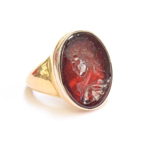 11 - A large and heavy Georgian gold mounted garnet intaglio portrait ring, the gold in two colours, the ... 