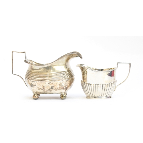 62 - A George III silver milk jug, of banded form, on four ball feet, London 1807; and a smaller milk jug... 