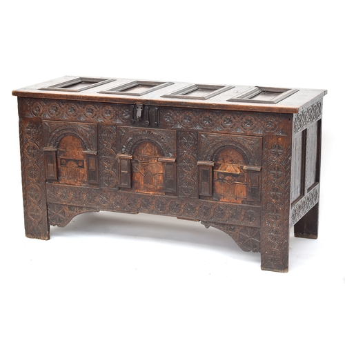 358 - A large 18th century Continental carved oak coffer, the four panel top over a profusely carved three... 