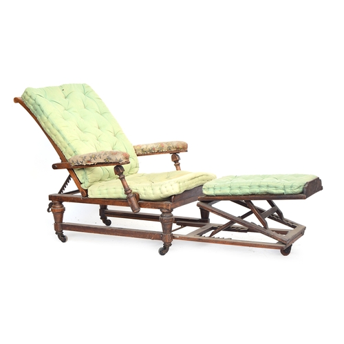 457 - A 19th century reclining open armchair, with a pull out adjustable footstool, caned back, seat, and ... 