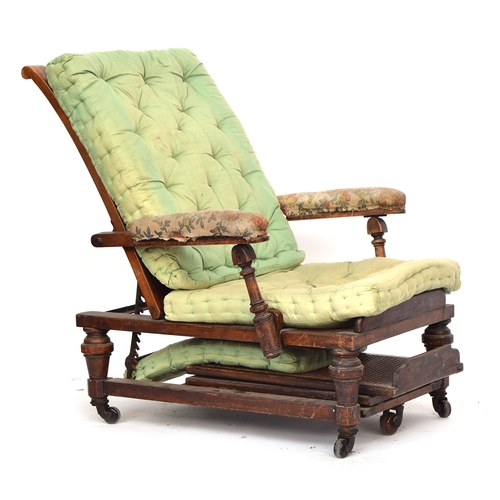 457 - A 19th century reclining open armchair, with a pull out adjustable footstool, caned back, seat, and ... 