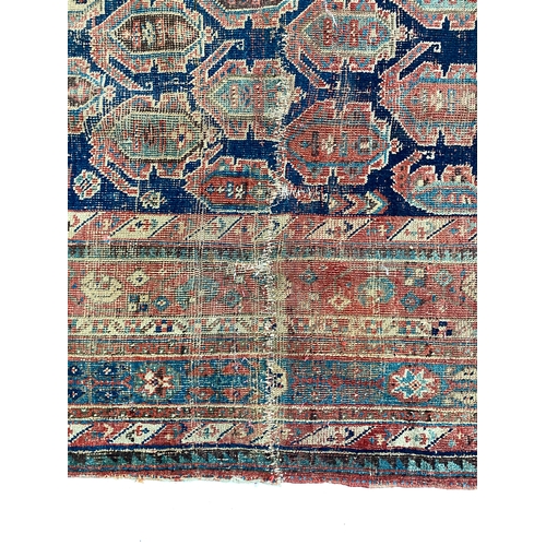 484 - A very long West Persian rug, the blue ground of boteh in a triple border, 555x220cm, some damage, e... 