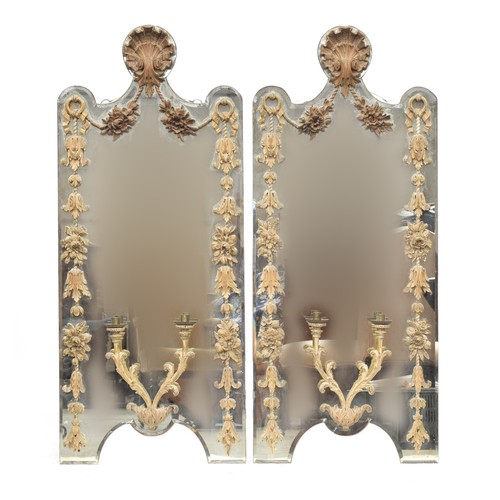 323 - A pair of early 20th century shaped girandole mirrors, with applied carved limewood detail, shell cr... 