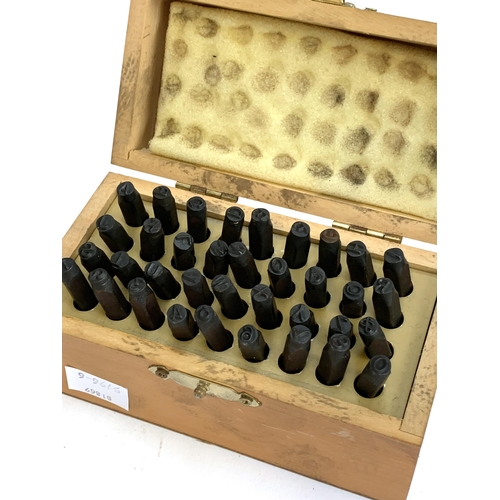 443 - A cased set of metal alphabet punch stamps; together with four boxes hip flasks including Royal Sela... 