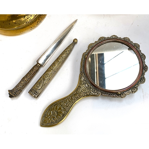 463 - A quantity of brass items to include Eastern brass hand mirror and letter knife; engraved brass tray... 