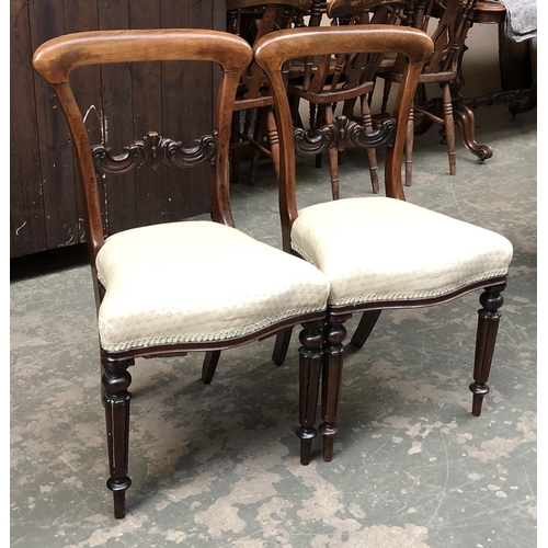 1243 - A pair of Victorian rosewood sidechairs with carved mid-rail, waisted seats, on lotus turned front l... 