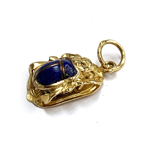 7 - An Egyptian gold and lapis scarab beetle pendant, tests as 14ct or higher, hallmarked on jump ring, ... 