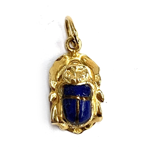 7 - An Egyptian gold and lapis scarab beetle pendant, tests as 14ct or higher, hallmarked on jump ring, ... 