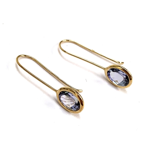 60 - A pair of 9ct gold mounted tanzanite hook earrings, the tanzanite totalling 2.7cts and measuring 8x6... 