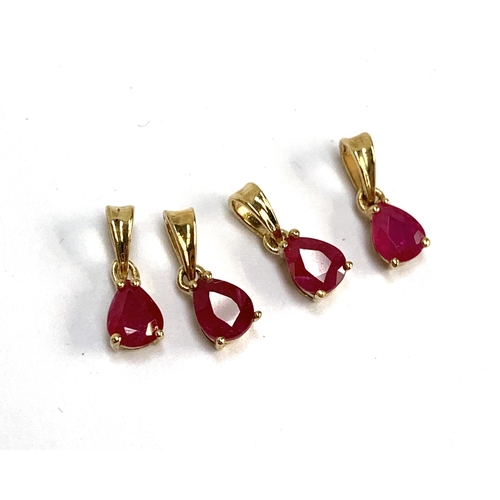 79 - Four small 9ct gold mounted ruby charm pendants, the Burmese rubies each 0.4cts and measuring 5x4mm,... 