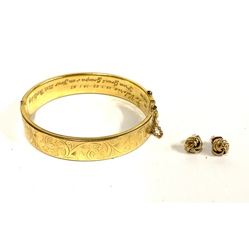 115A - A pair of 9ct gold knot earrings, 1.5g gross weight; together with a rolled gold engraved bangle