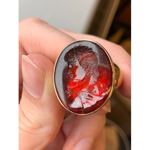 11 - A large and heavy Georgian gold mounted garnet intaglio portrait ring, the gold in two colours, the ... 