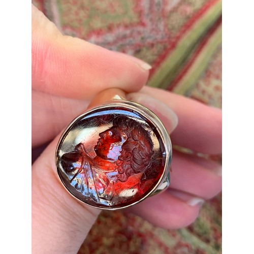 11 - A large and heavy Georgian gold mounted garnet intaglio portrait ring, the gold in two colours, the ... 