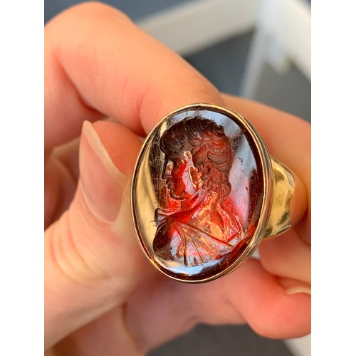 11 - A large and heavy Georgian gold mounted garnet intaglio portrait ring, the gold in two colours, the ... 