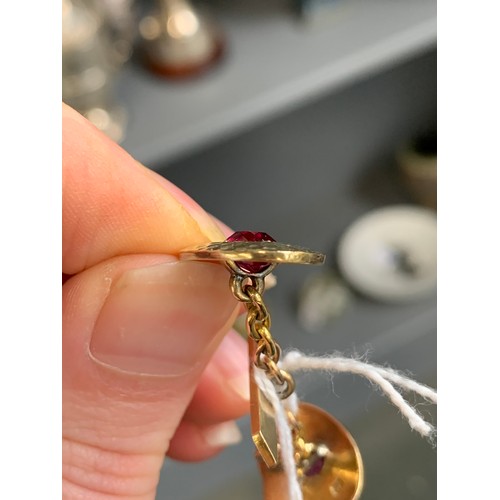 31 - A matched pair of early 20th century French 18ct gold and ruby Art Deco cufflinks with a planished f... 