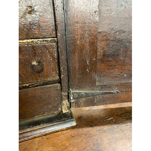 354 - A Charles II oak spice cupboard, the geometric carved door with applied half turned decoration, open... 